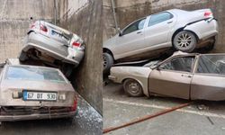 Rampadan geri kayıp 8 metrelik duvardan düştü: Park halindeki aracın üzerine çıktı